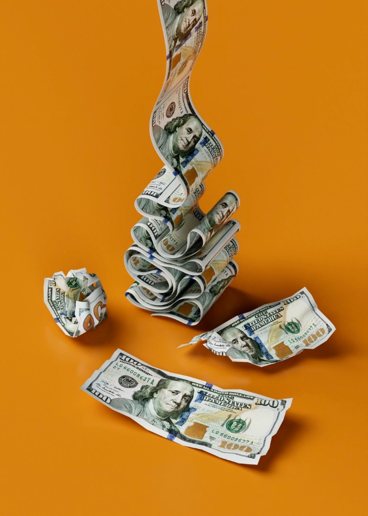 US dollar bills arranged on an orange background